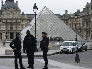 French police officers stand in front of the Louvre in Paris