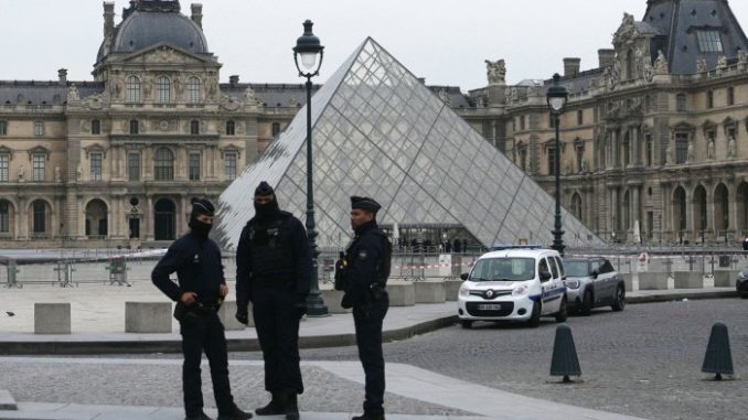 French police officers stand in front of the Louvre in Paris