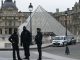 French police officers stand in front of the Louvre in Paris