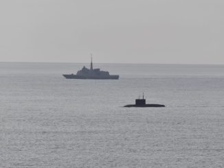 A French Navy vessel watches the surfaced Russian sub Novorossiysk this week.