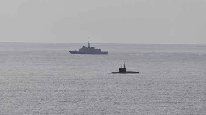 A French Navy vessel watches the surfaced Russian sub Novorossiysk this week.