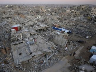 People walk among extensive rubble and destroyed buildings in Gaza City during a ceasefire.