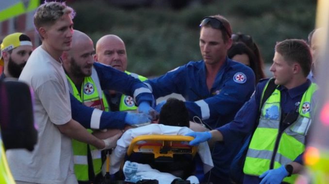 Emergency workers and paramedics transport a person on a stretcher, attending to injuries after a reported shooting.
