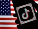 In this photo illustration, the social media application logo, TikTok is displayed on the screen of an iPhone on an American flag background on August 3, 2020 in Arlington, Virginia. - The US Senate voted on August 6, 2020, to bar TikTok from being downloaded onto US government employees' telephones, intensifying US scrutiny of the popular Chinese-owned video app. The bill passed by the Republican controlled Senate now goes to the House of Representatives, led by Democrats. (Photo by Olivier DOULIERY / AFP) (Photo by OLIVIER DOULIERY/AFP via Getty Images)