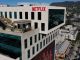 Netflix logo atop Sunset Bronson Studios office building with the Hollywood sign visible in the distant hills.