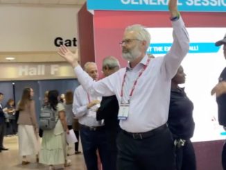 Police escort Dr. Steven Kahn out of a medical conference in New Orleans for handling out copies