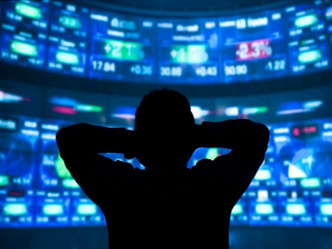 young man standing in front of the projection reflected stock market