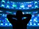 young man standing in front of the projection reflected stock market