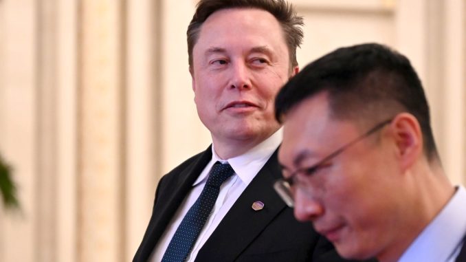 Tech billionaire and Tesla founder Elon Musk walks through the Great Hall of the People.