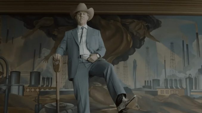 elderly man in a light blue suit and cowboy hat and boots holding a shovel